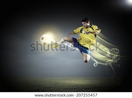 Young football player on stadium in jump taking ball