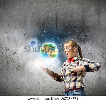Woman in casual wear holding opened book in hands. Elements of this image are furnished by NASA