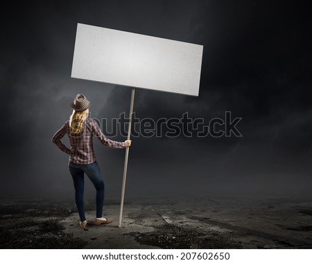 Young woman in casual carrying white blank banner