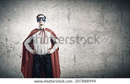 Young confident man in mask and cape
