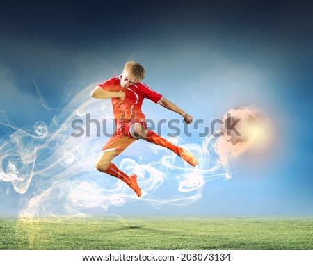 Young football player on stadium kicking ball in jump