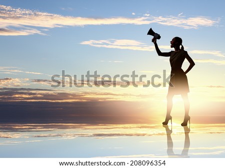 Silhouette of woman at sunset screaming in megaphone