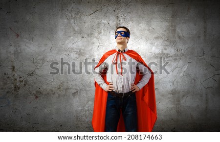 Young confident man in mask and cape