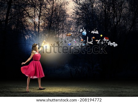 Young woman in red dress walking in night wood