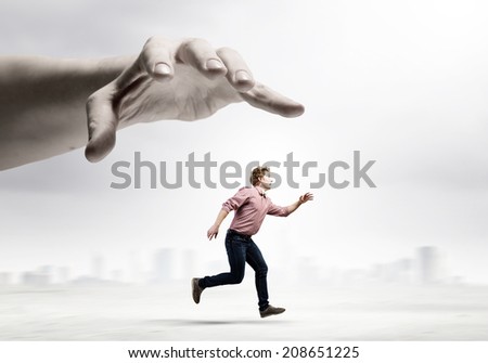 Young man trying to run away from big male hand