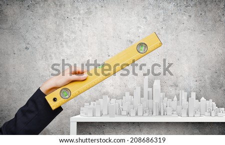 Close up of female hand measuring construction project with ruler