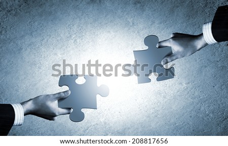 Close up image of hands connecting puzzle elements