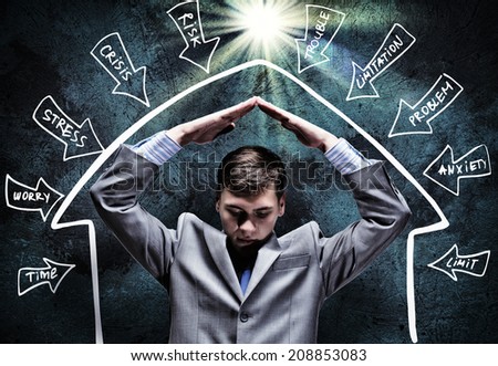 Young businessman under rain covering head with hands