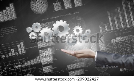 Close up of business person hand holding gears