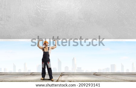 Strong man in uniform lifting wall above head