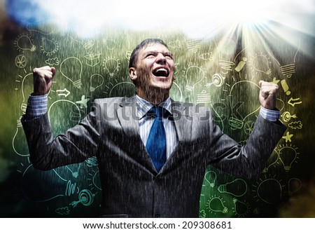 Cheerful businessman with hands up celebrating success