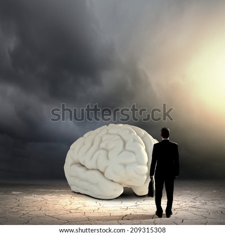 Rear view of businessman looking at big brain model