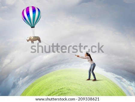 Young woman in casual and rhino flying in sky