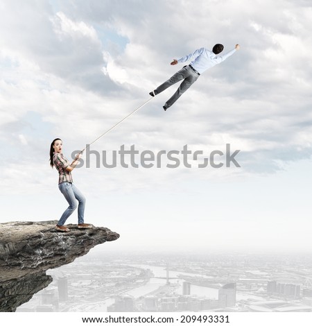 Woman holding on lace businessman trying to escape