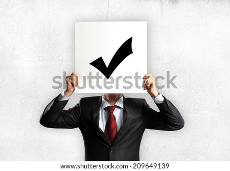 Businessman hiding his face with sheet of paper with sketches at background