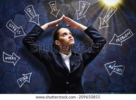 Young troubled businesswoman protecting head with with hands