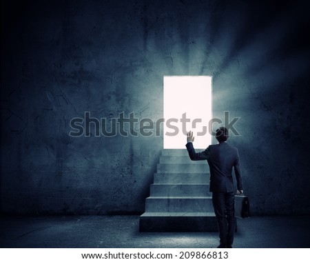 Silhouette of businessman with briefcase standing in doorway