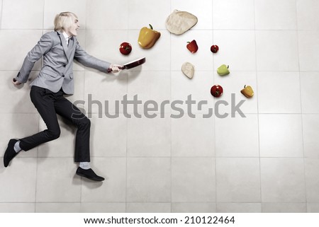 Young funny businessman running with pan in hand
