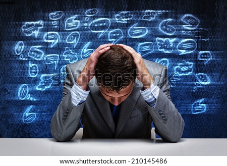 Troubled young businessman covering head with hands