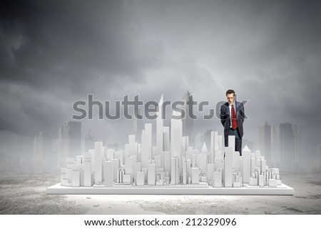 Young businessman examining model of construction project Young businessman examining model of construction project