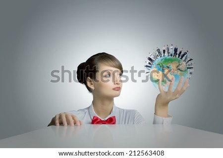 Young smiling woman holding balloon colored like Earth planet. Elements of this image are furnished by NASA