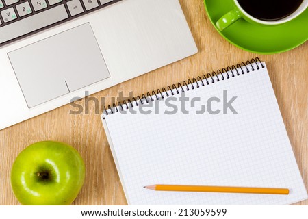 Laptop cup of coffee and notepad at table
