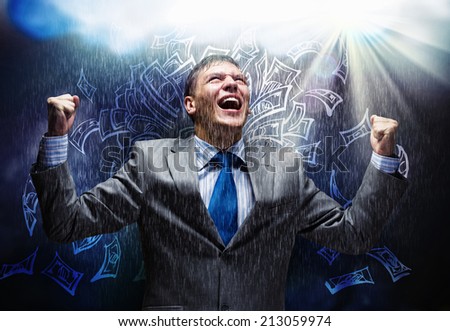 Cheerful businessman with hands up celebrating success