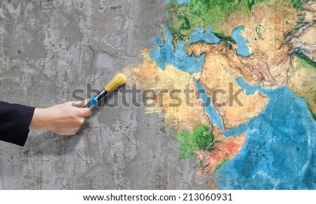 Close up of business person hand painting Earth planet. Elements of this image are furnished by NASA