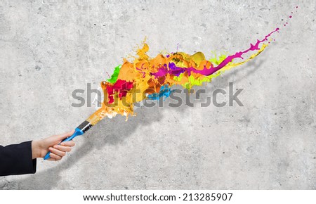 Close up of business person hand holding paint brush