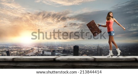 Young pretty woman walking with suitcase in hand