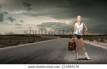Young woman hiker standing with suitcase in hand