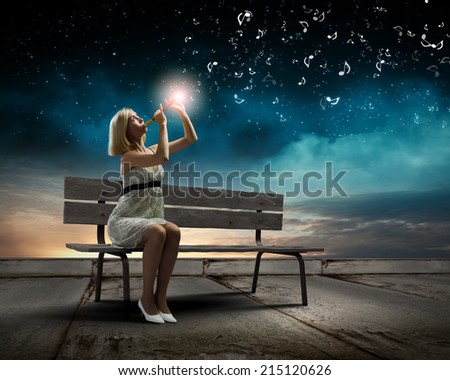 Young woman sitting on bench and playing fife