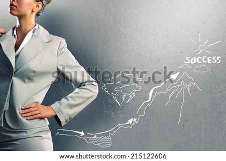 Close up of businesswoman and business sketches on cement wall