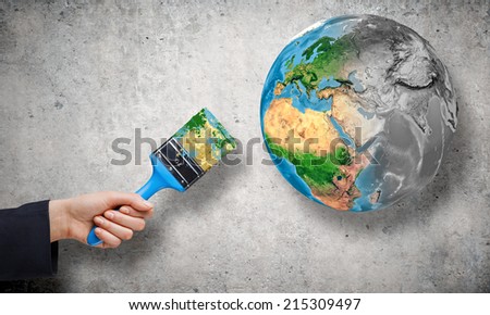 Close up of business person hand painting Earth planet. Elements of this image are furnished by NASA