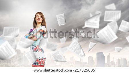 Young woman in casual and paper flying in air