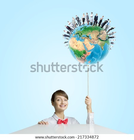 Young smiling woman holding balloon colored like Earth planet. Elements of this image are furnished by NASA