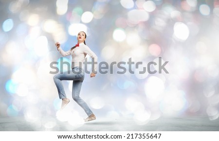 Young funny pretty woman in jeans running in a hurry