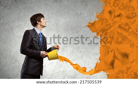 Young businessman holding in hands yellow bucket
