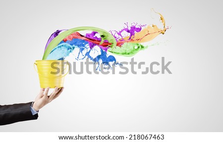 Close up of businessman hand holding bucket with paint
