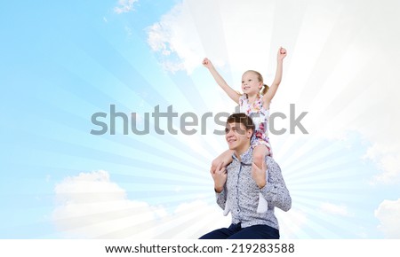 Happy daughter sitting on shoulders of her father
