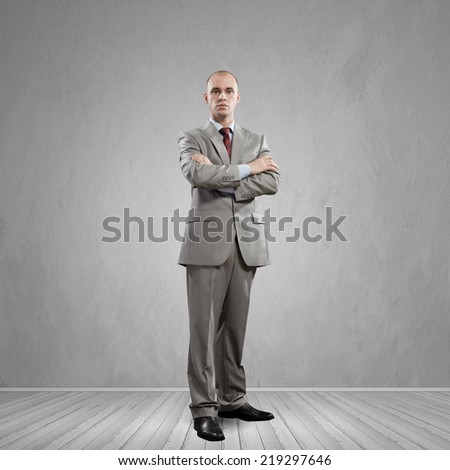 Young successful handsome businessman in suit in empty room