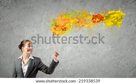Young attractive businesswoman with paint brush in hand