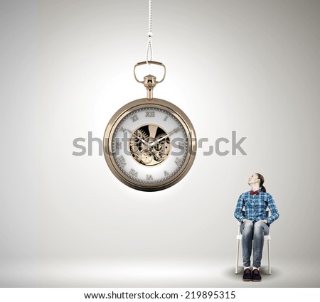 Young woman in casual looking at pocket clock
