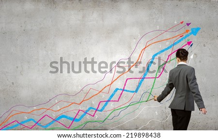 Young businesswoman drawing increasing graph with brush