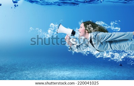 Young businesswoman in suit swimming in crystal blue water