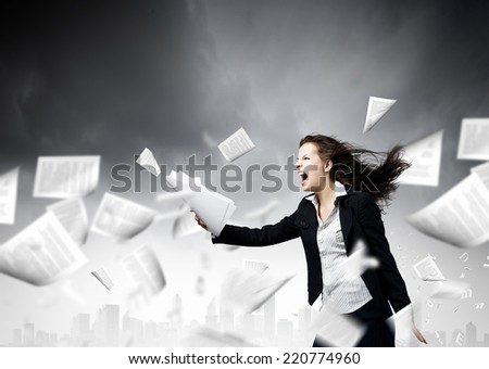 Young determined businesswoman walking against strong wind