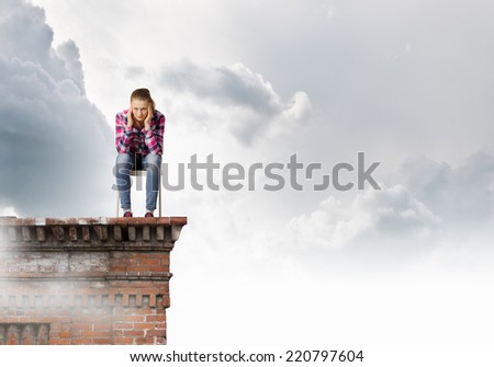 Young thoughtful woman in casual sitting in chair