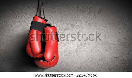 Pair of red boxing gloves hanging on wall