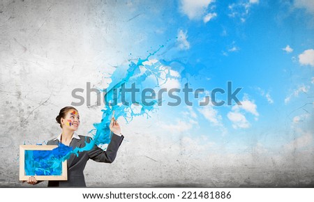 Young attractive woman in suit with paint brush in hand