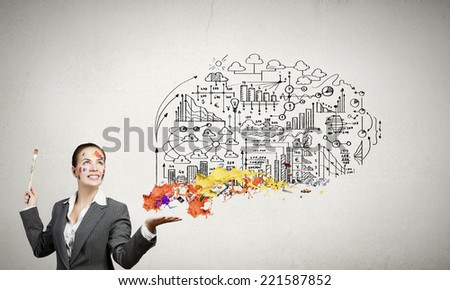 Young attractive businesswoman with paint brush and colorful business sketches